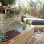 Intégration de spa avec terrasse bois, bardage et massif minéral