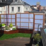 Piscine sur balcon avec terrasse bois gazon synthétique et occultation bois